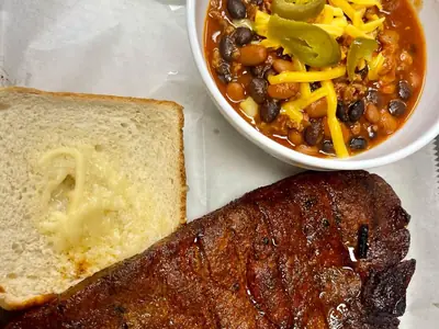 Smoked pork steak with Texas toast and a bowl of BBQ chili